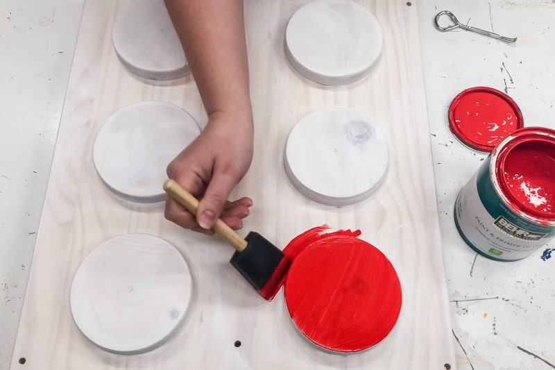 painting side of IKEA Lego table bright red with foam brush