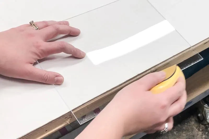 sanding the cut edge of an acrylic sheet