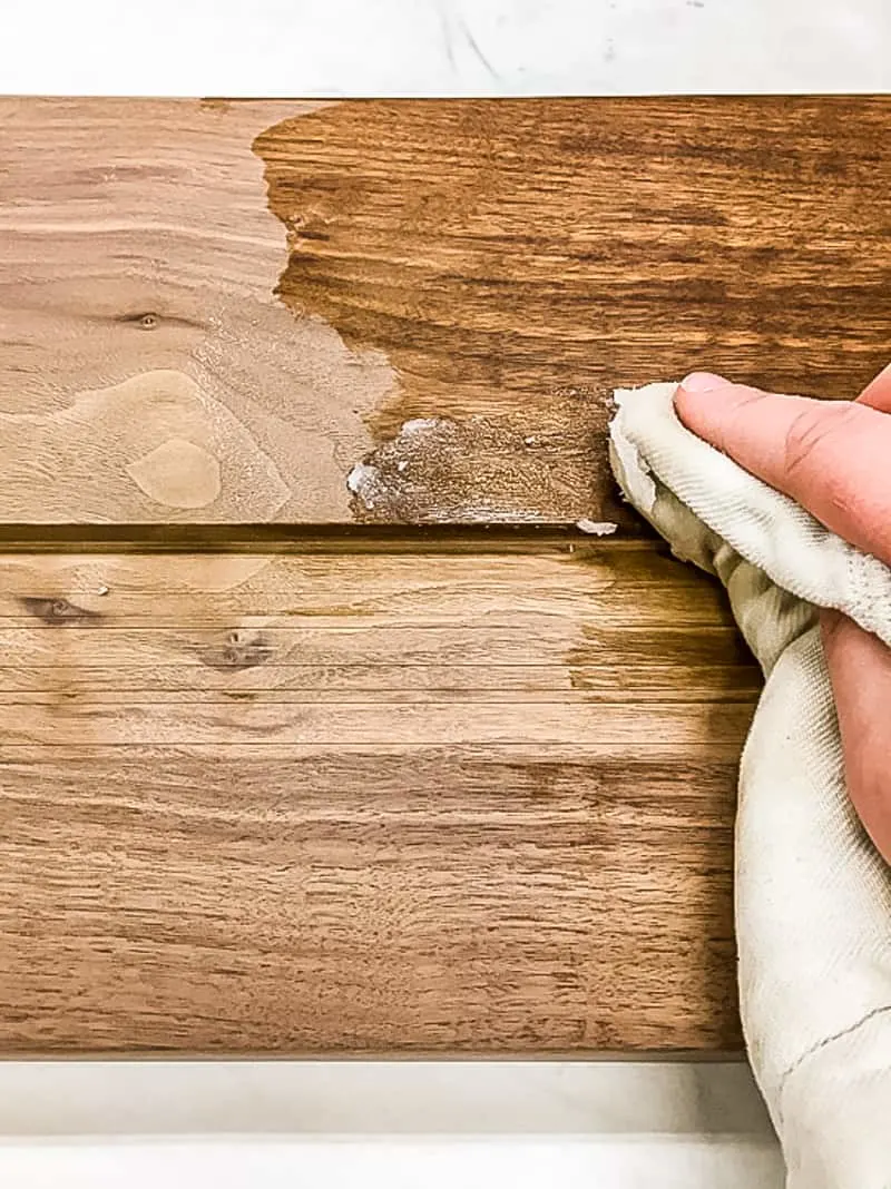applying cutting board wax to walnut cutting board with a cloth