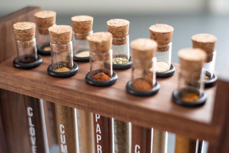 close up view of DIY spice rack with corks in the top of each test tube