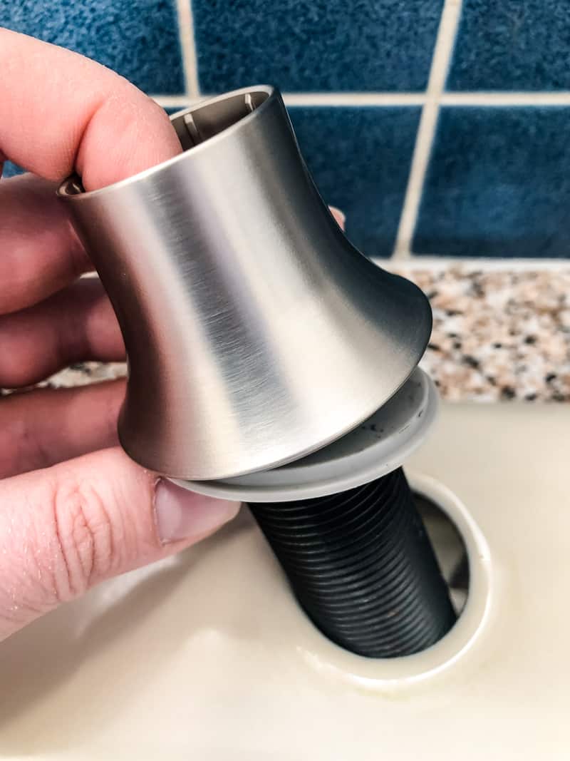 dropping new soap dispenser into kitchen sink hole