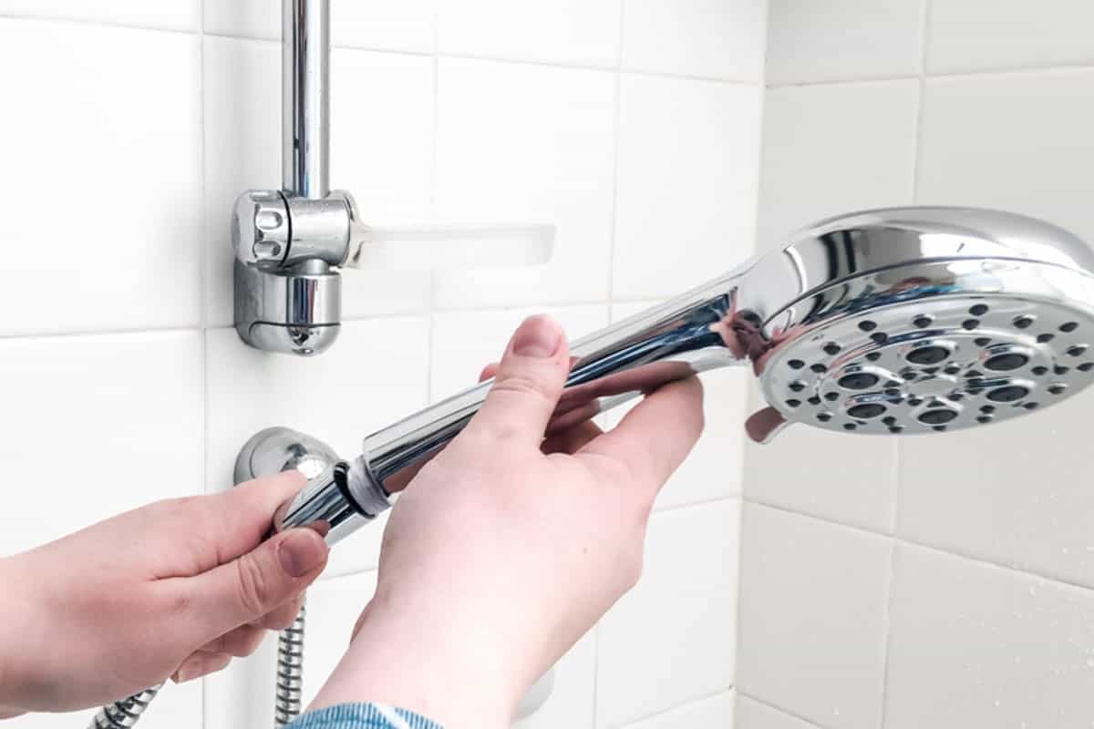 screwing handheld shower head on to hose