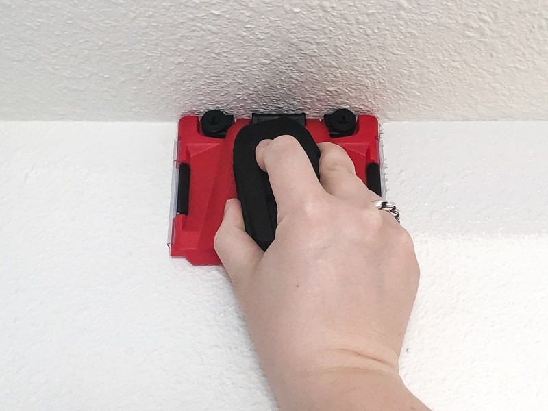 Paint edging tool running along ceiling with heavy texture