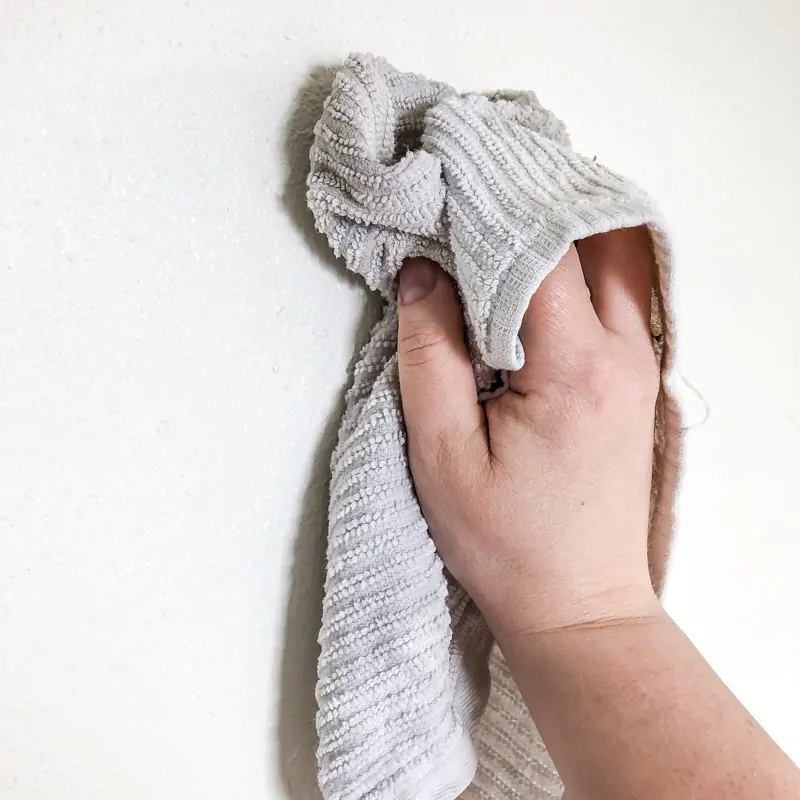 wiping down white textured walls with a damp rag before painting