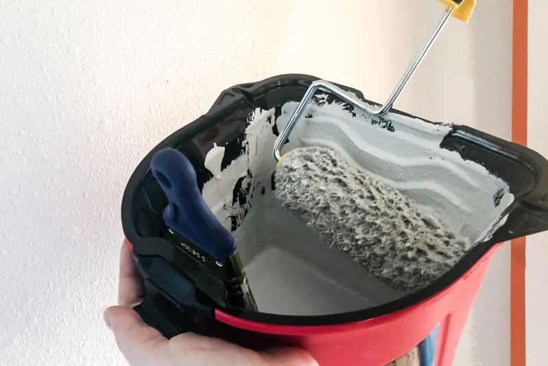 HANDy Pro Pail in hand with paint roller on side