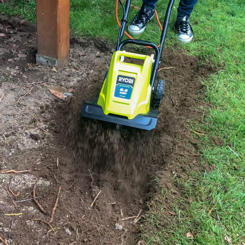 Ryobi cultivator loosening soil for pea gravel patio