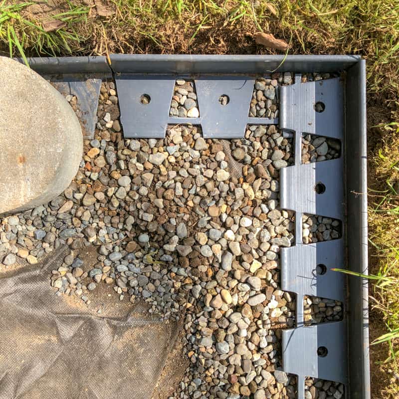 paver edging being installed around pea gravel patio