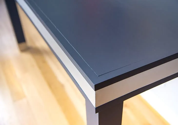 corner of dark blue desk with aluminum band