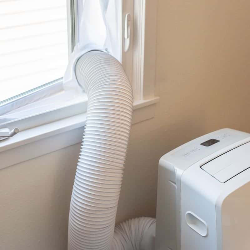 portable air conditioner in crank out window with fabric screen around opening