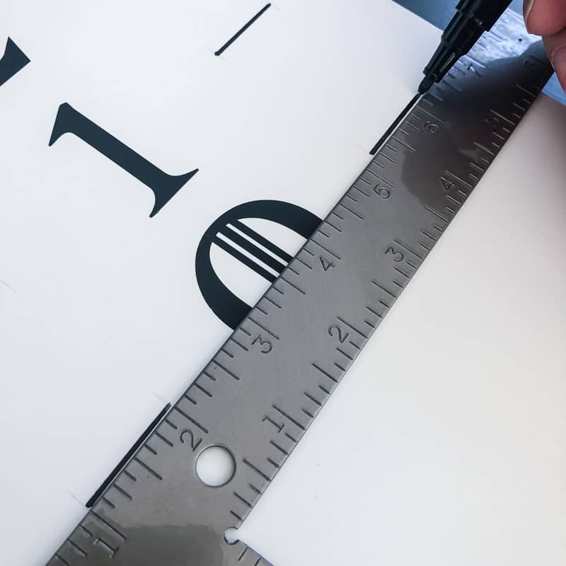 marking the sides of the cornhole scoreboard with a black paint pen