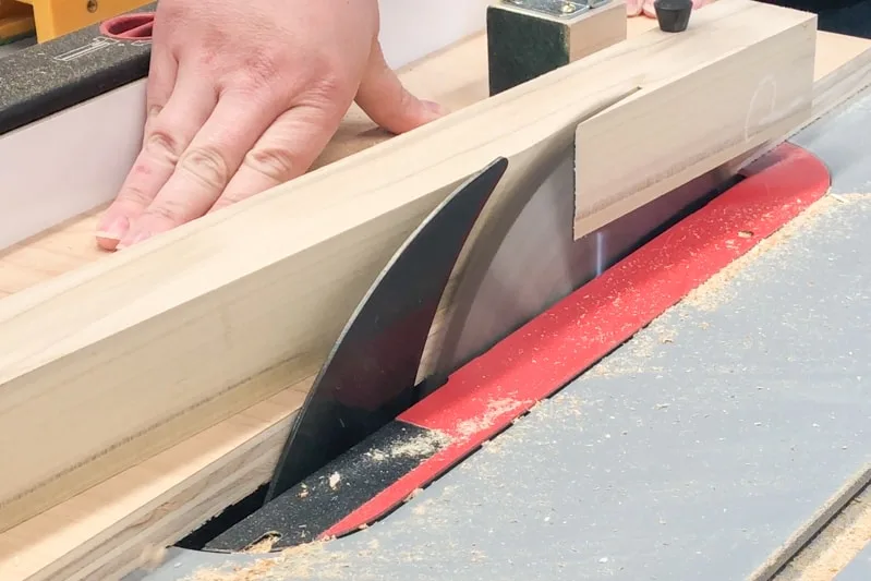 cutting tapered legs for DIY nightstand on the table saw with a tapering jig