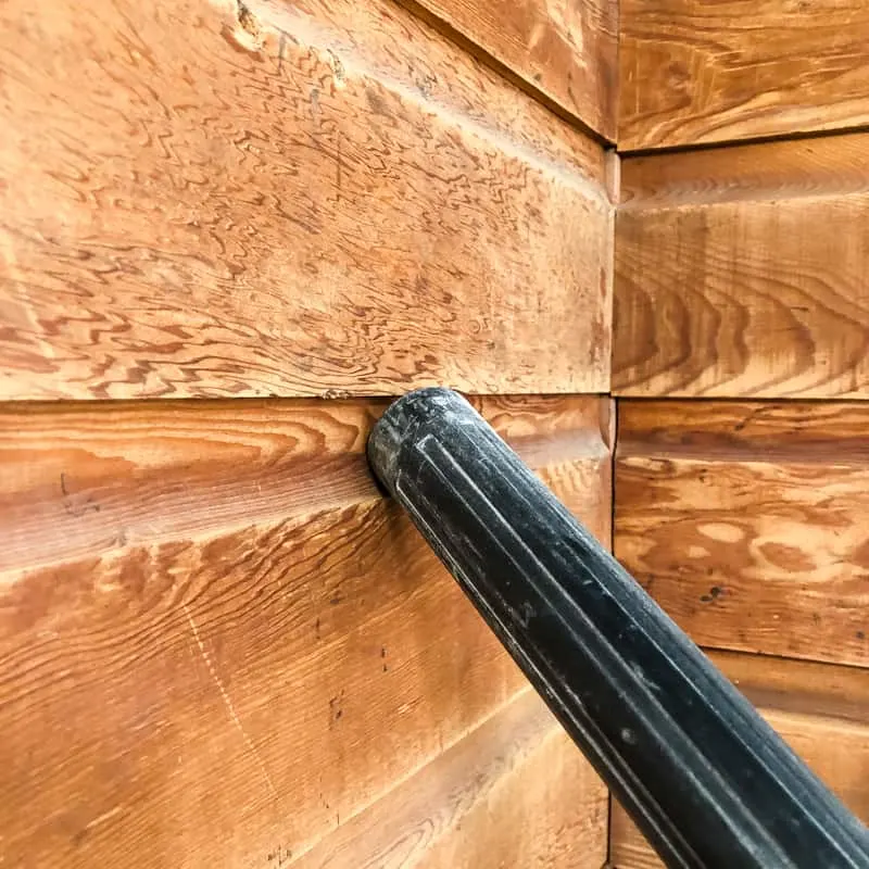 vacuum attachment sucking dust off of wood paneling
