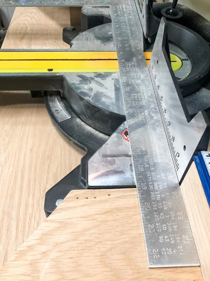 metal ruler on miter saw base to check fence