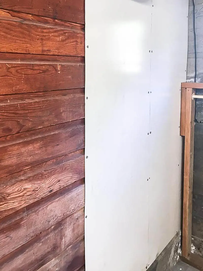wood paneled wall covered with white board on half