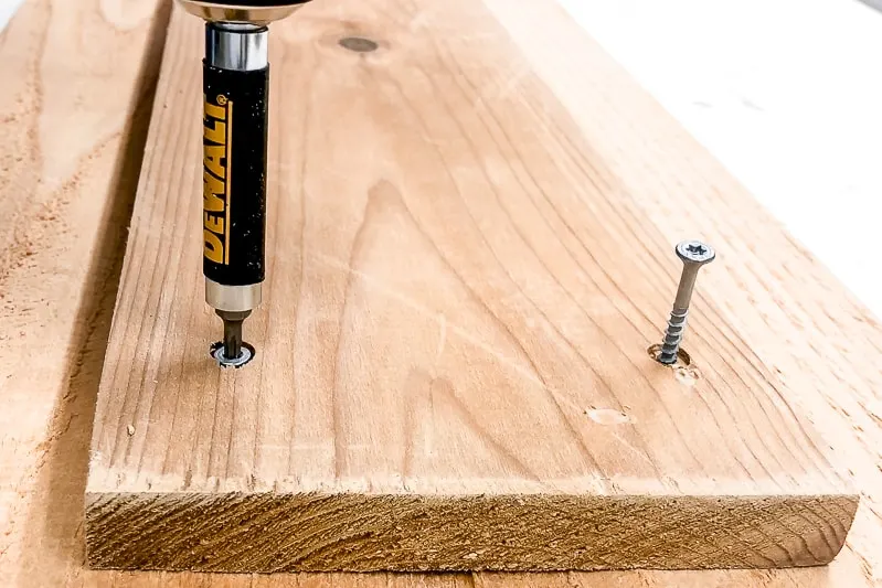 screwing countersink screws into bottom board of deck rail table