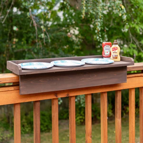 railing table with paper plates and condiments on top