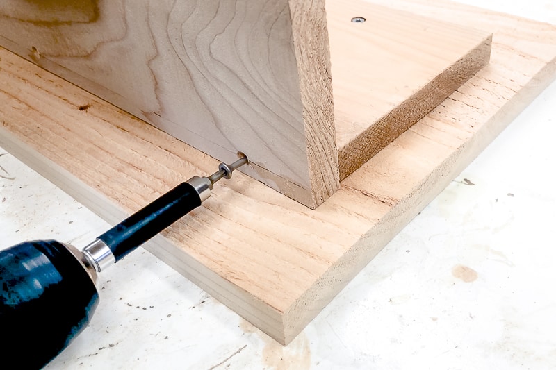 Screw the sides to the bottom of the balcony railing table with countersunk screws.