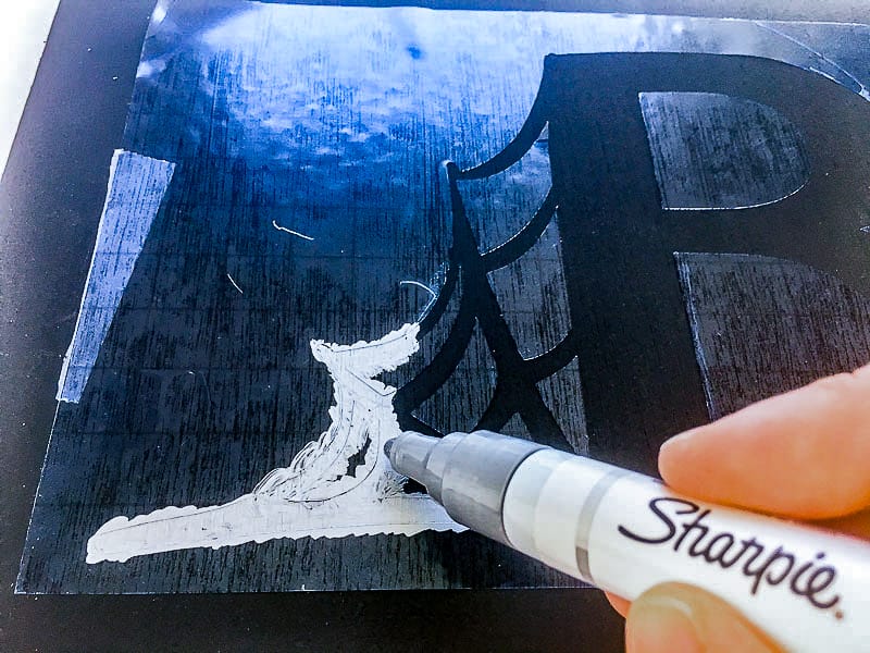 applying silver paint to spider stencil