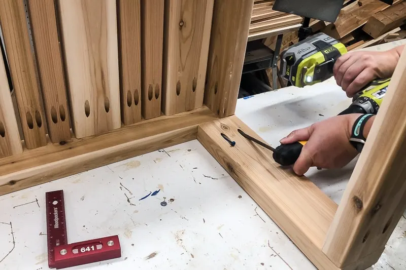 using right angle drill attachment to screw pocket holes into legs of 2x4 coffee table