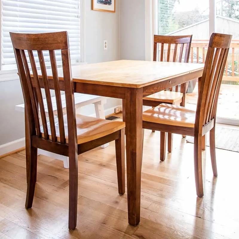 two toned dining table in need of refinishing