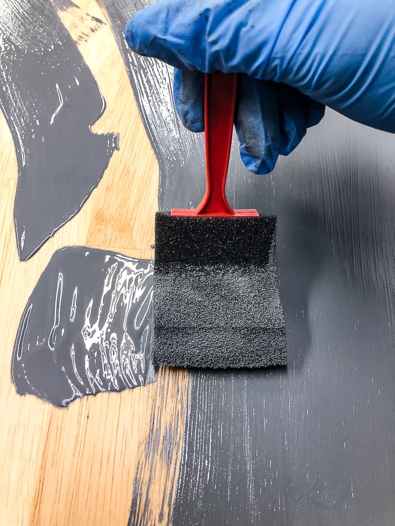 applying grey gel stain to a refinished table