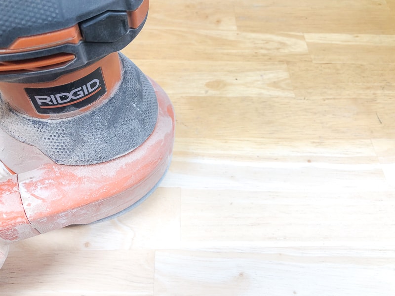 Ridgid random orbit sander being used to refinish a dining table