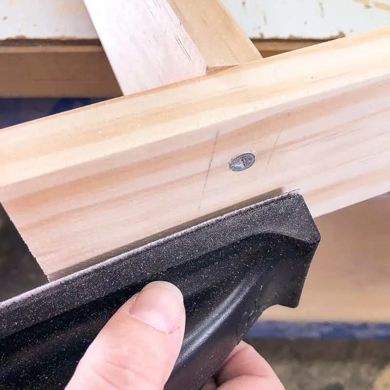 sanding off pencil marks from side of DIY blanket ladder