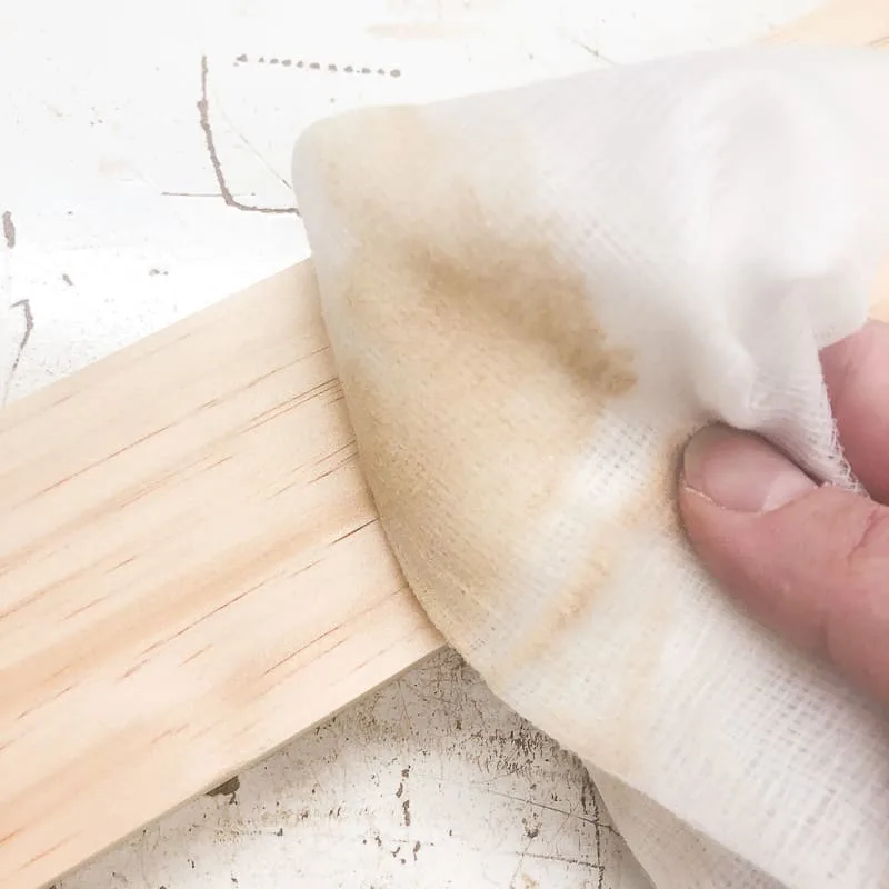 removing sanding dust from wood surface with a tack cloth