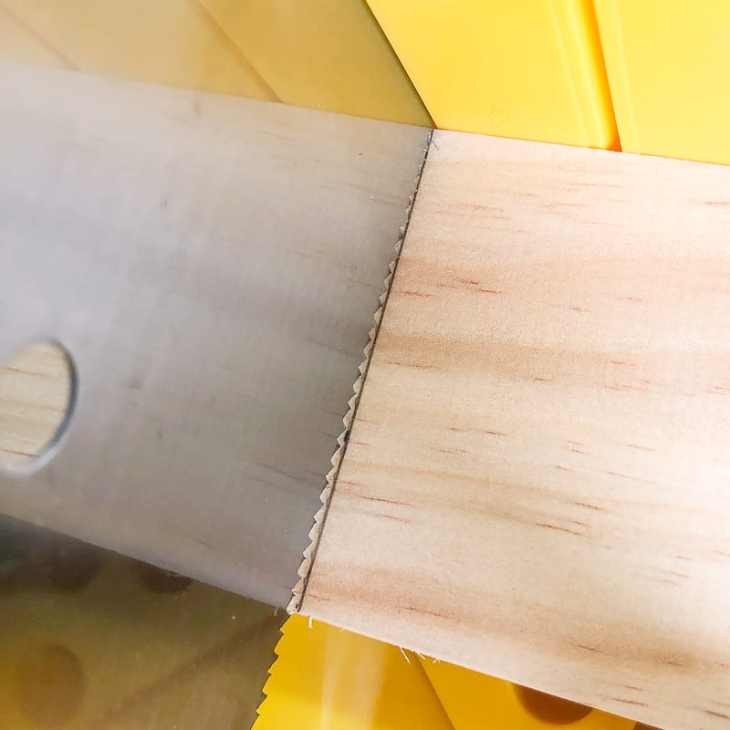 lining up teeth of saw with the waste side of the cut line on the board