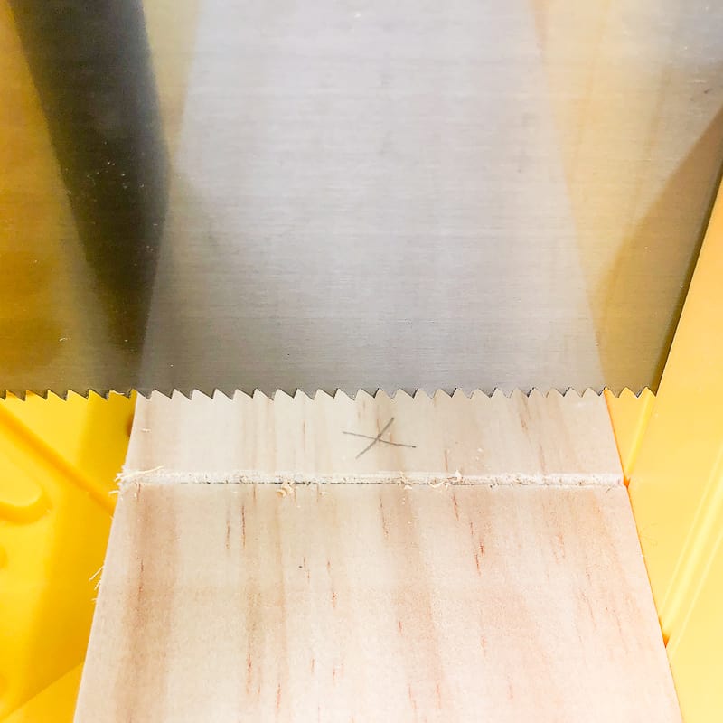 scoring the cut line with the saw in a miter box