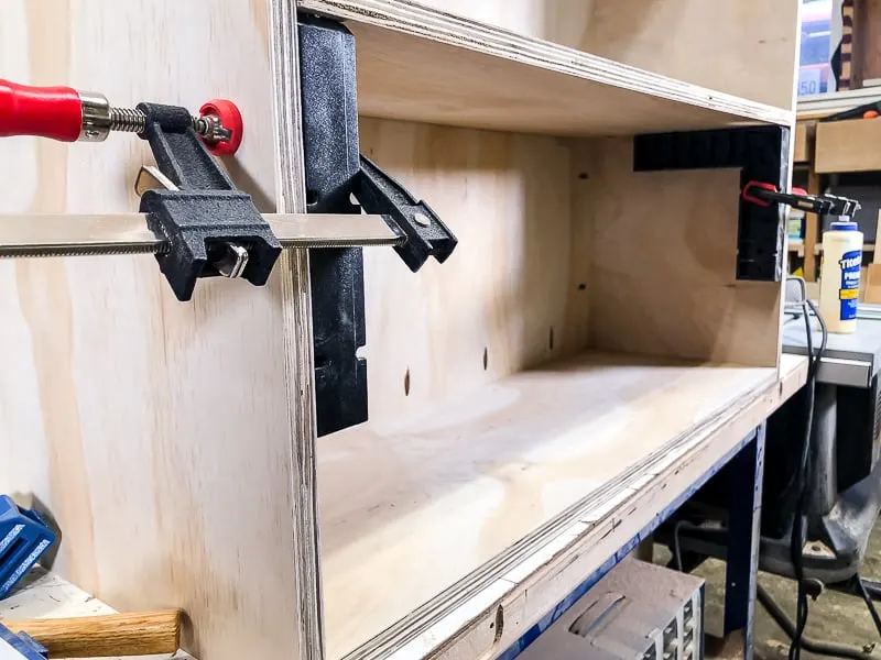 first shelf of DIY workbench being installed