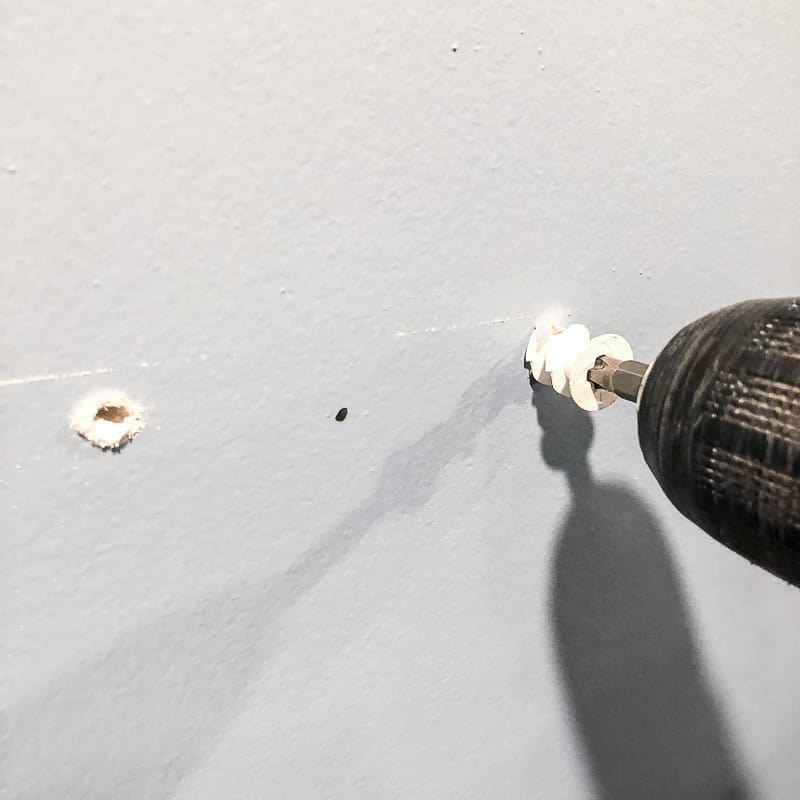 screwing wall anchors into the wall