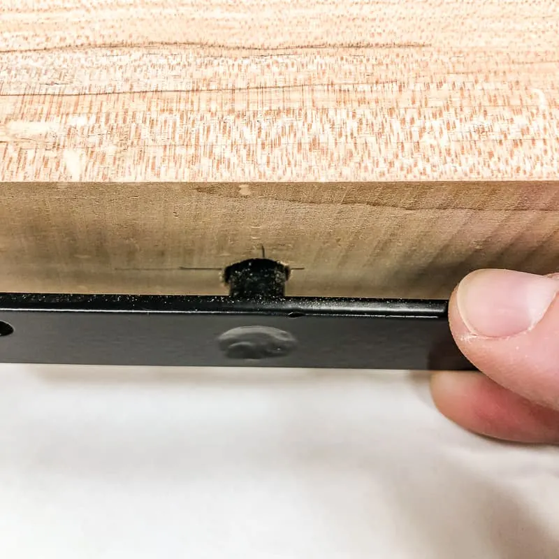 checking fit of floating shelf hardware in hole
