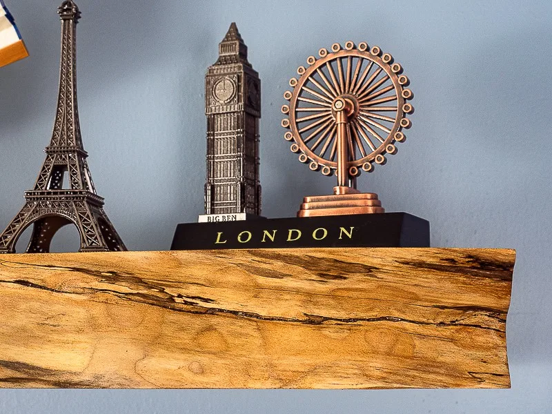 travel souvenirs on live edge floating shelf