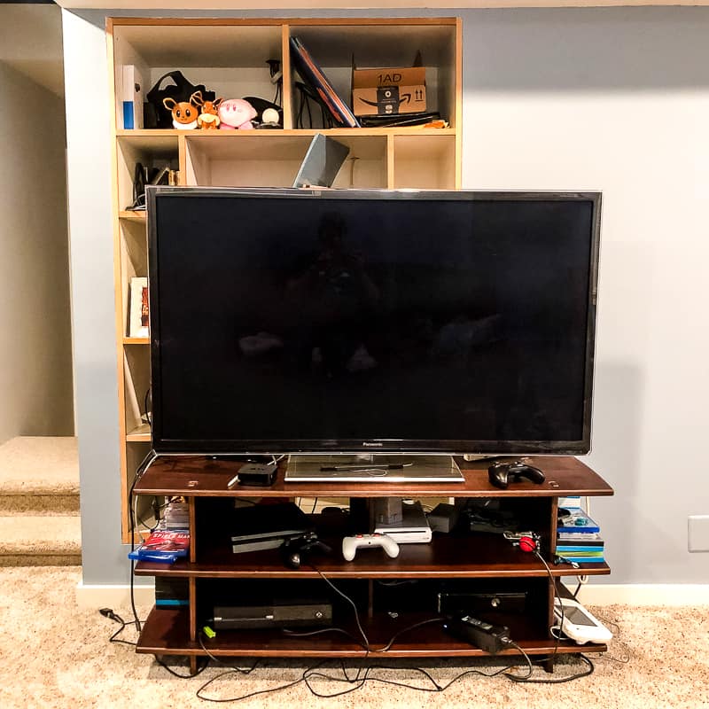 flat screen tv on stand in front of built in entertainment center