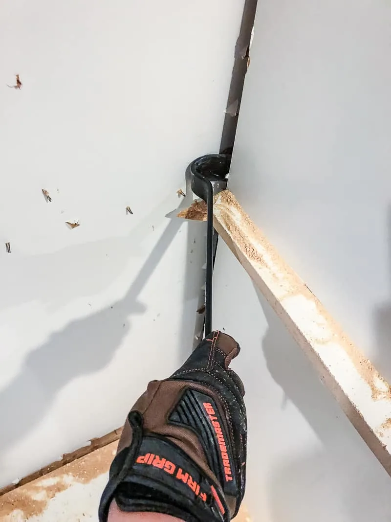 removing an old built in entertainment center with a crowbar