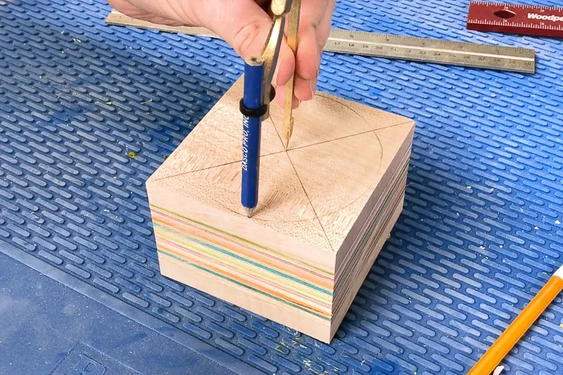drawing a circle with a compass on a block of wood