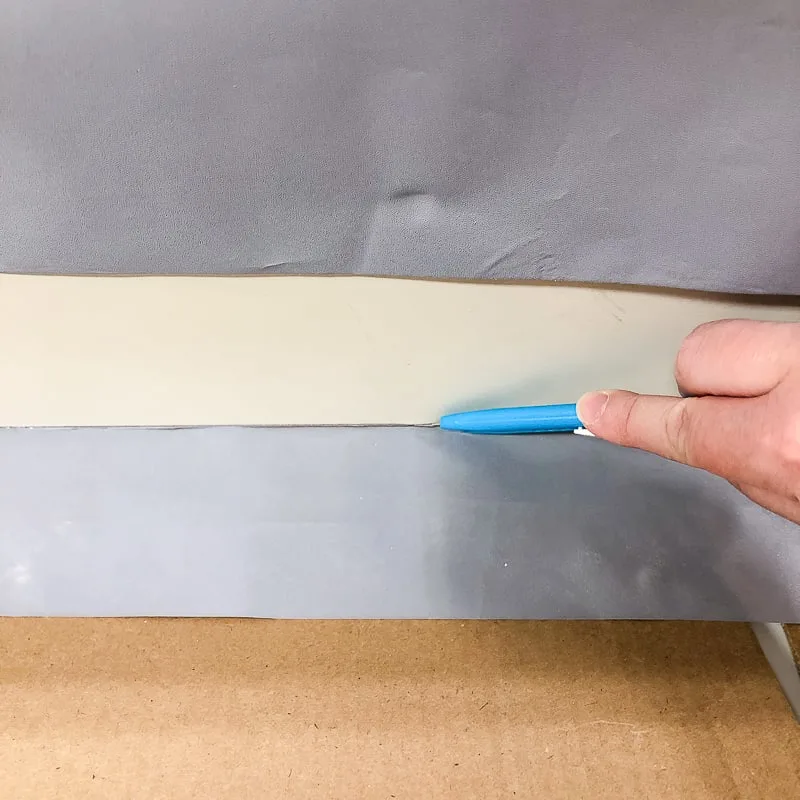 cutting away excess contact paper with a razor blade