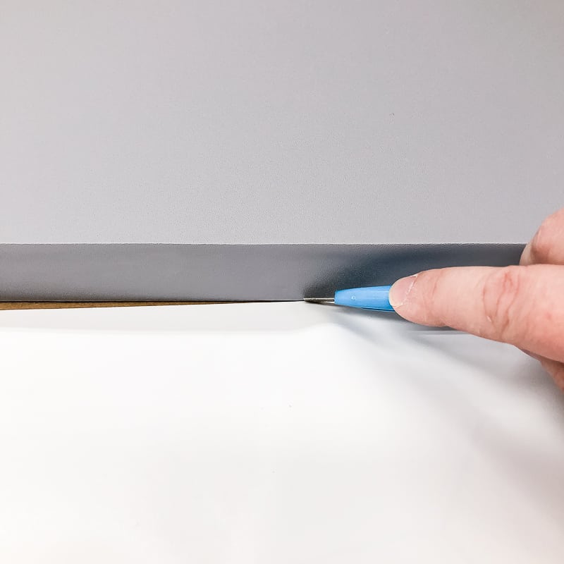 trimming excess patterned contact paper with a razor blade
