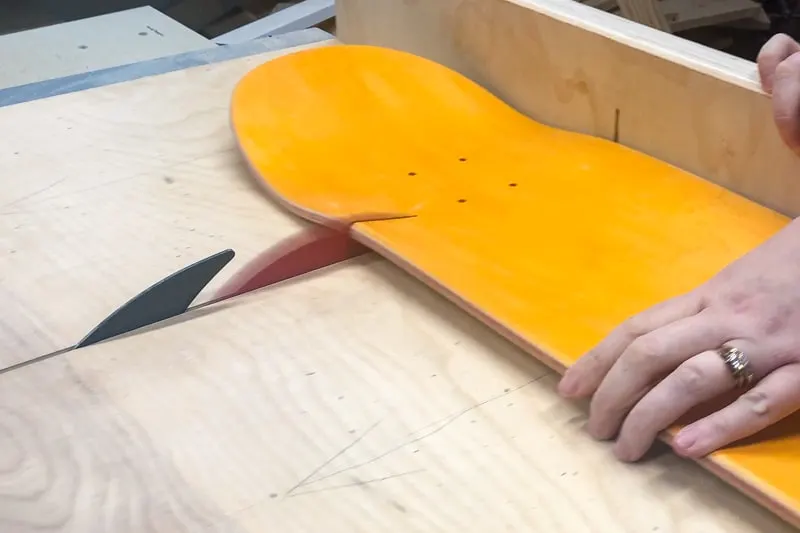 cutting nose off yellow skateboard with table saw and crosscut sled