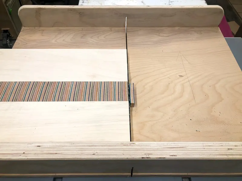 trimming off excess from the sides of the laptop stand top with a table saw