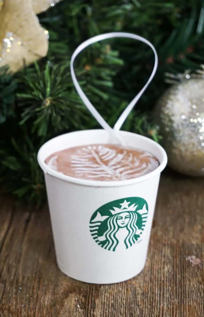 DIY Starbucks latte ornament on table with Christmas decor in background