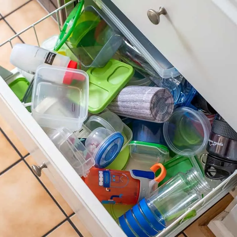 kitchen drawer with a mess of plastic containers