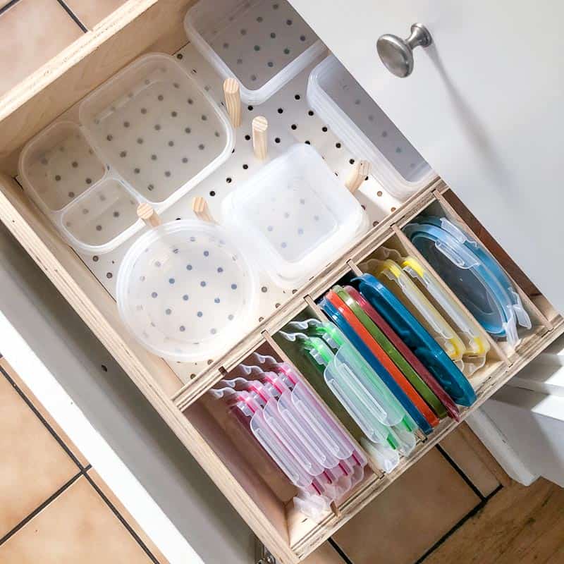 plastic containers and lids neatly organized in a DIY drawer organizer