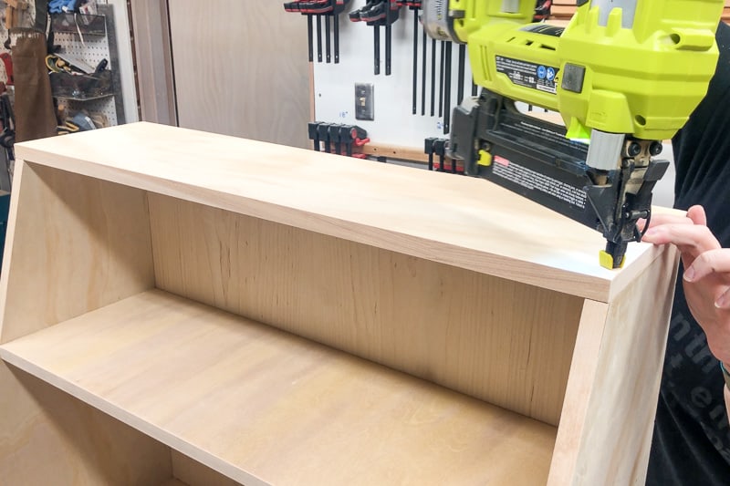 Attach the top of the bookshelf to the sides and back with a nail gun and pocket hole screws.