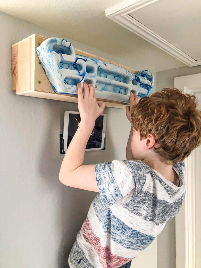 kid using hangboard while watching ipad