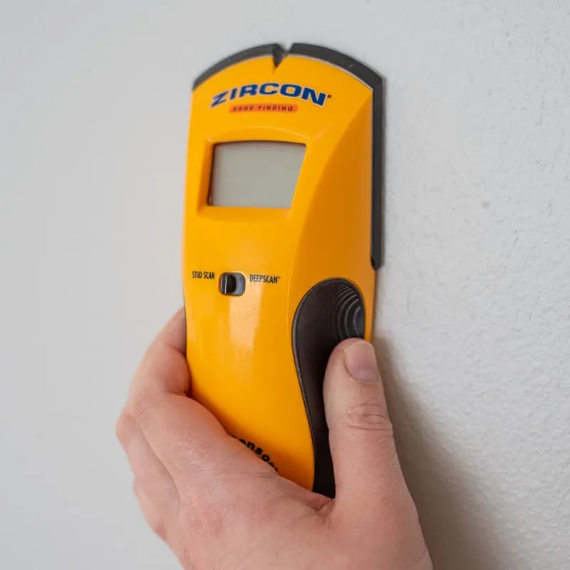 holding electronic stud finder to the wall in the off position