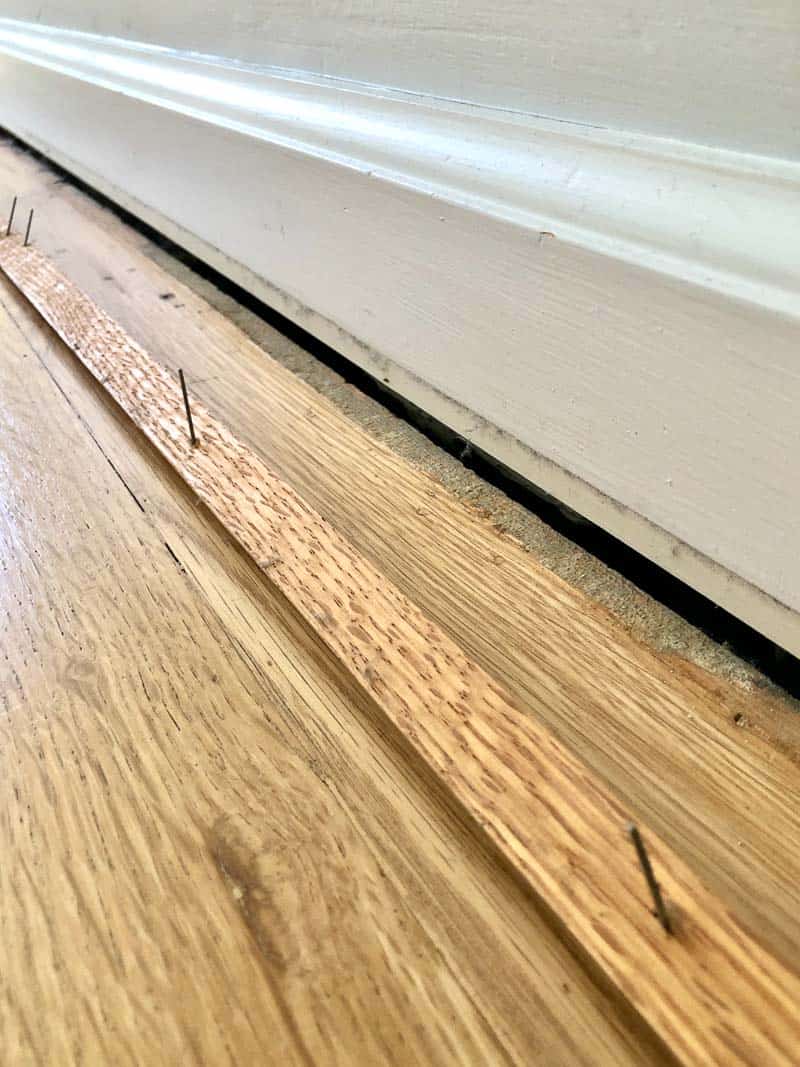 baseboards with quarter round removed to expose gap