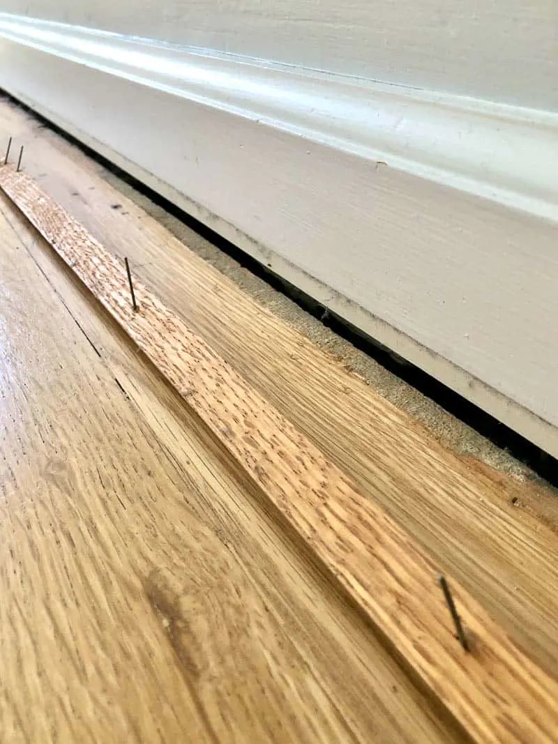 baseboards with quarter round removed to expose gap
