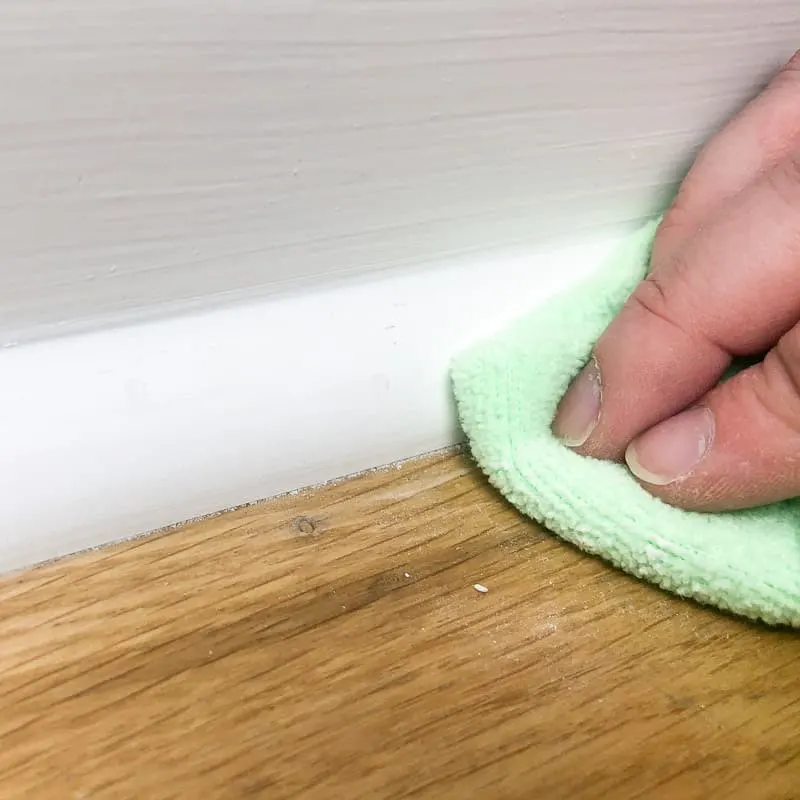 removing sanding dust with a microfiber cloth before painting baseboards